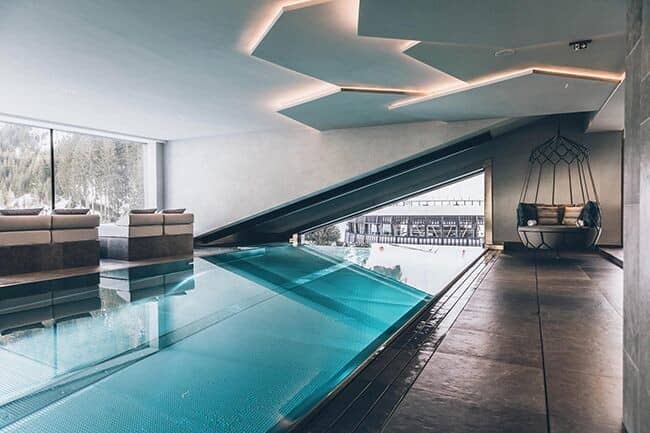 Indoor-outdoor infinity pool with swim-through access and mountain views