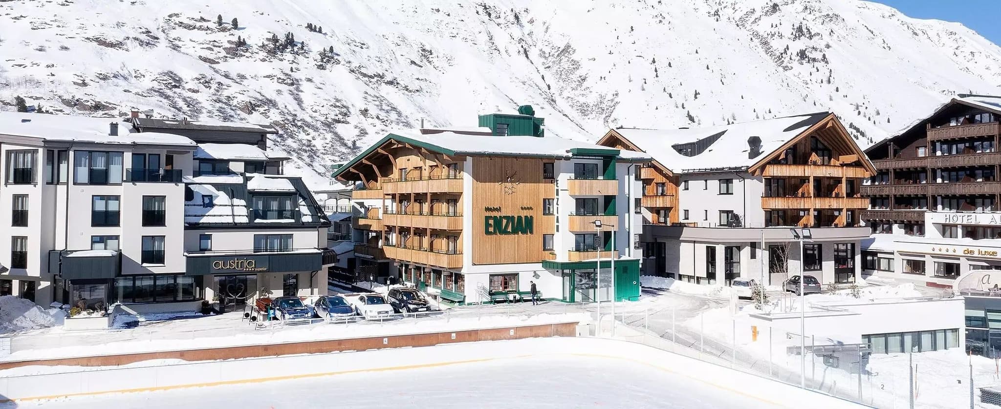 Ski-in/ski-out hotel exterior with mountain views and outdoor ice rink
