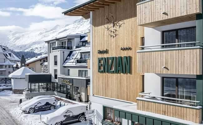 Hotel Enzian exterior with private balconies and mountain views