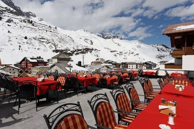 Shared rooftop terrace with table seating and alpine mountain views