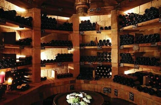 Stone wine cellar with barrel tasting table and custom brick shelving