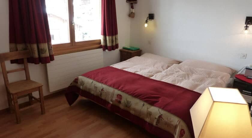 Guest bedroom with two twin beds pushed together and blackout curtains