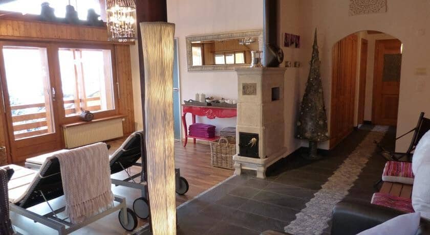 Living area featuring wood-burning masonry heater and terrace access