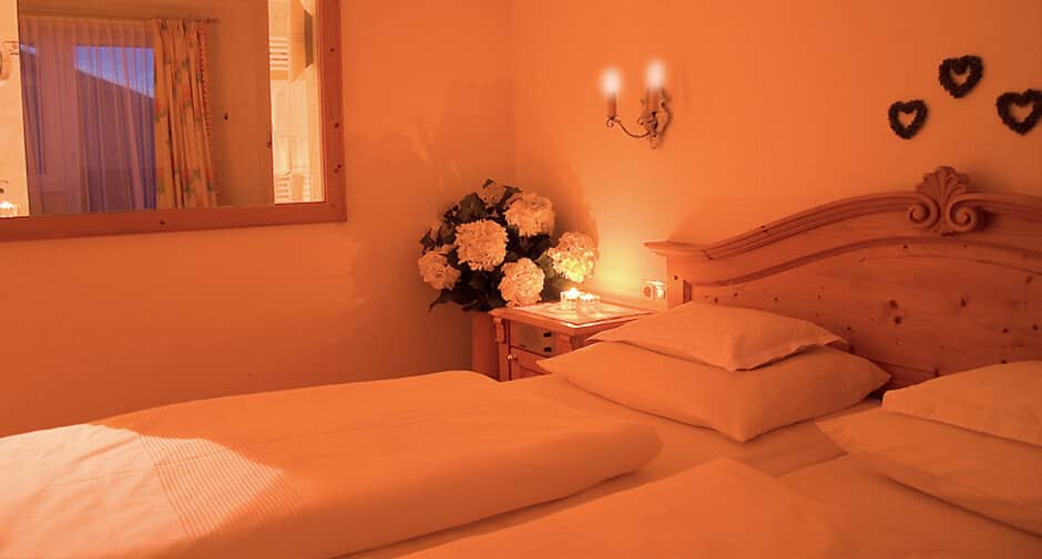 Guest bedroom with pine headboard and bedside lighting