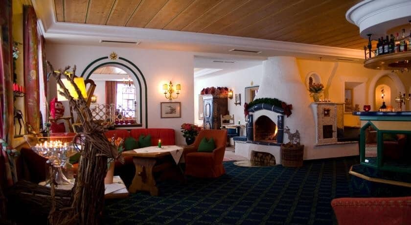 Lounge area featuring wood-burning kachelofen fireplace and adjacent wet bar