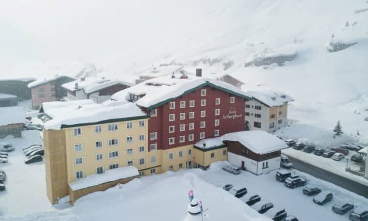 Ski-in/ski-out hotel exterior with on-site parking and mountain backdrop