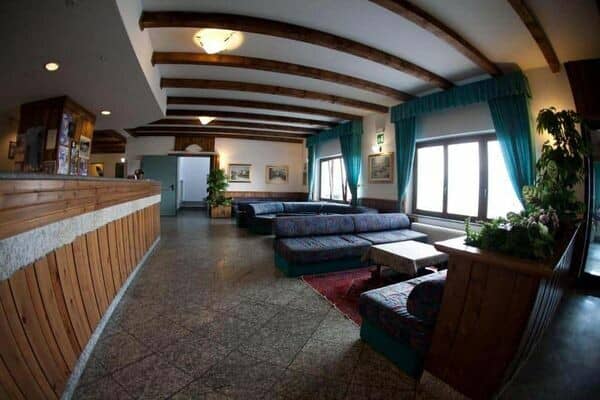 Lounge area with exposed ceiling beams and sectional seating for 15