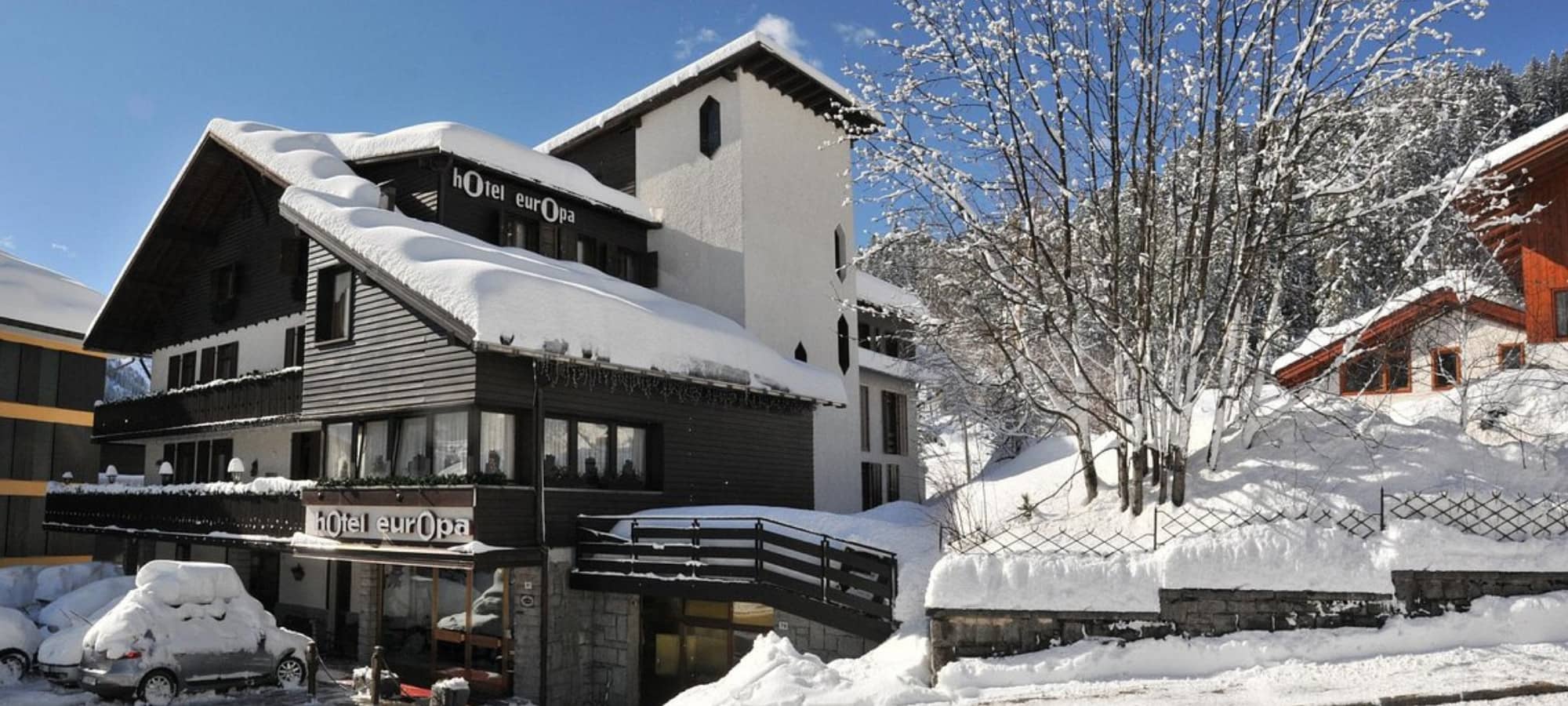 Chalet exterior with timber facade and snow-covered terrace