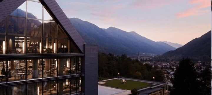 Floor-to-ceiling windows overlooking the valley and surrounding mountains at dusk