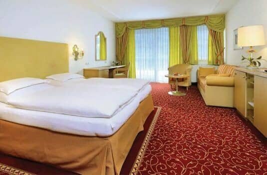 Guest suite with king bed, sofa seating, and dedicated work desk