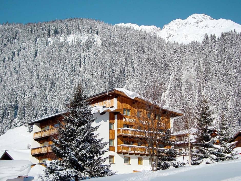 Chalet exterior with private balconies and snow-covered mountain views