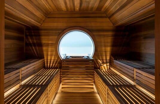 Cedar sauna with tiered seating and circular porthole window