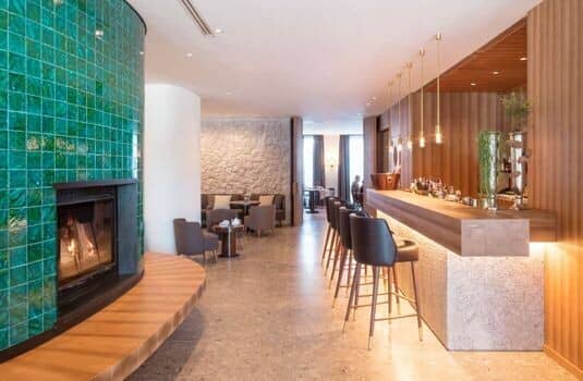 Lounge area featuring green tile fireplace and bar seating