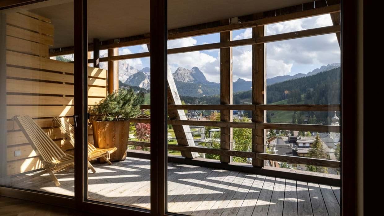 Private balcony with lounge seating and panoramic Dolomite mountain views