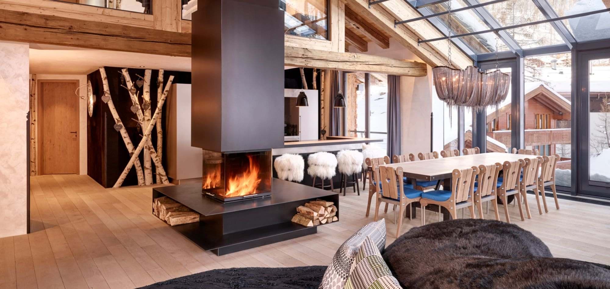 Open living area with central wood-burning fireplace and dining for 12
