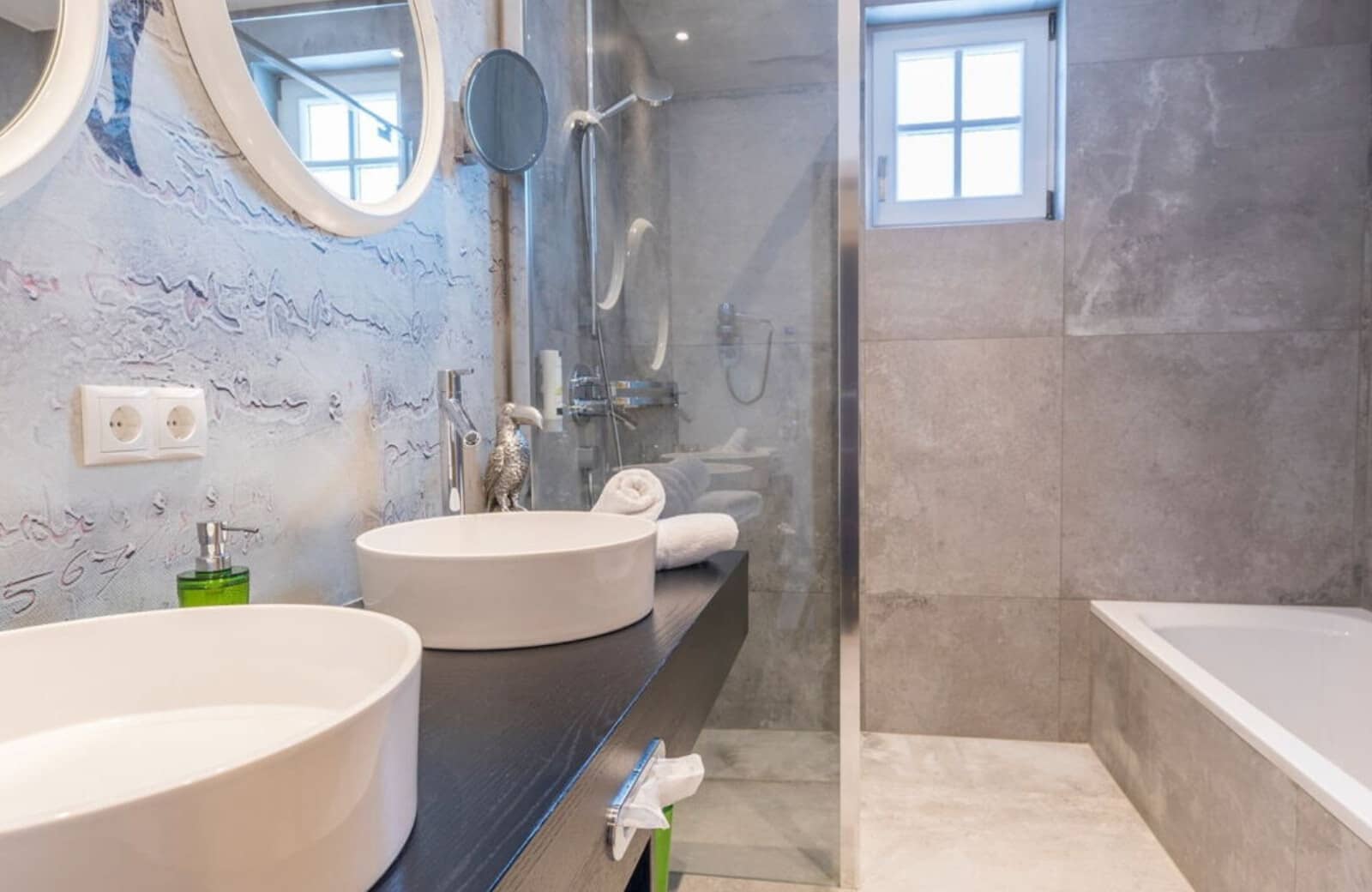 Bathroom with dual vessel sinks, walk-in shower, and soaking tub