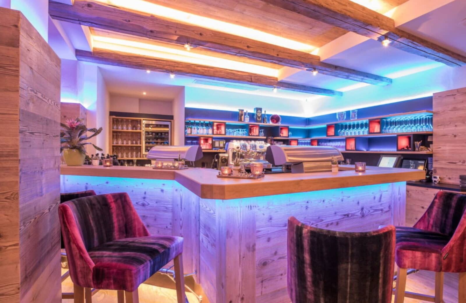 Private bar with espresso machine, wine cooler, and neon cove lighting
