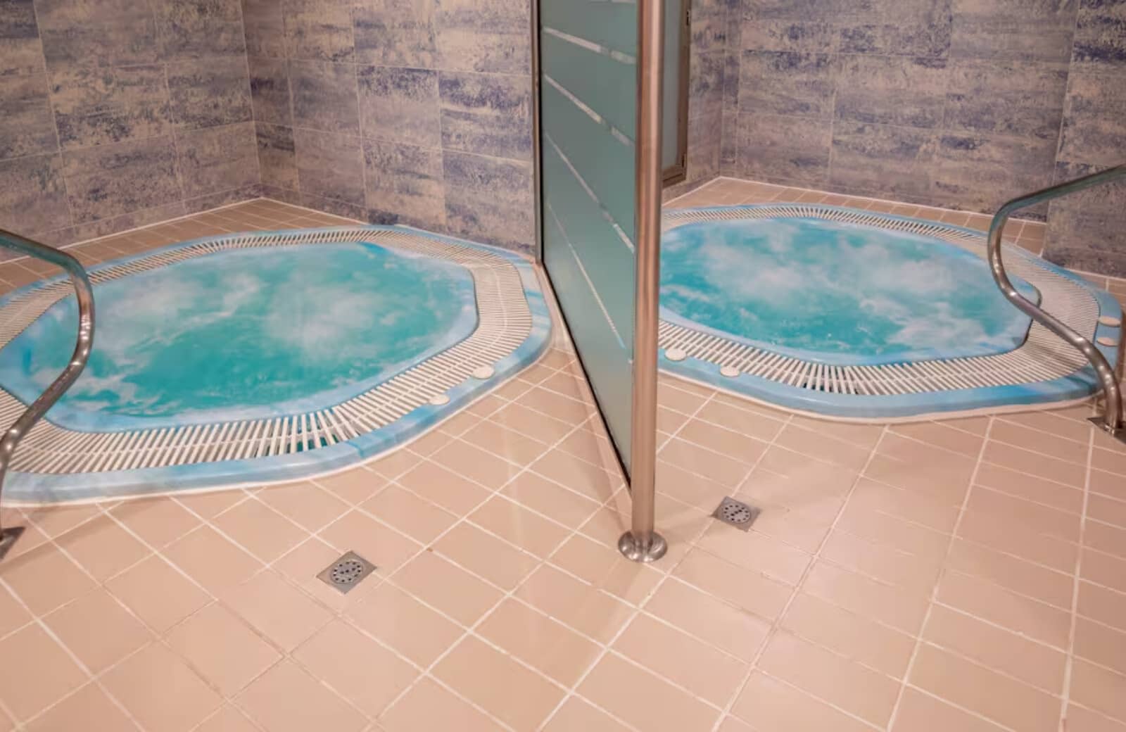 Dual indoor hot tubs with privacy partition and handrail access