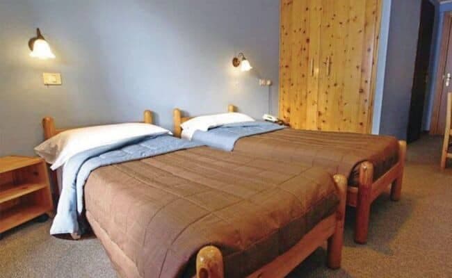 Guest bedroom with twin log beds and large built-in wardrobe