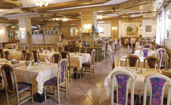 On-site dining room with traditional wood paneling and seating for large groups