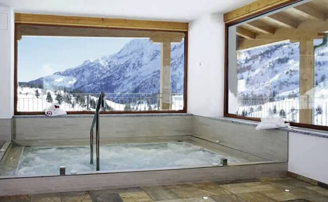 Indoor heated pool with handrail and panoramic mountain views