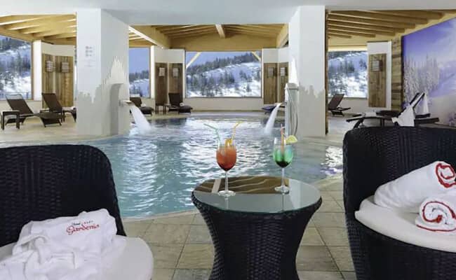 Indoor heated pool with massage waterfalls and mountain views