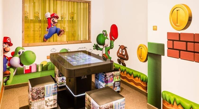 Nintendo themed game room with touchscreen arcade table and cube seating