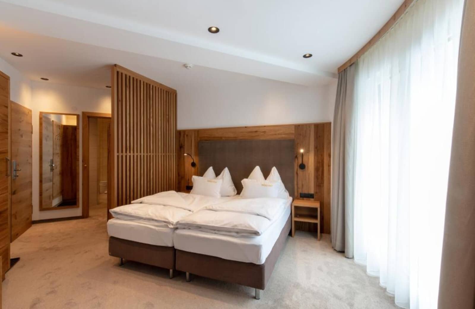 Bedroom with split-king bed and wood-slat privacy screen