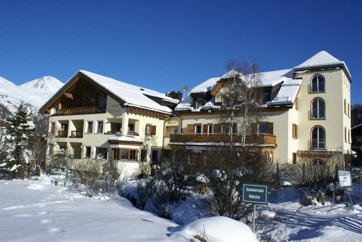 Property exterior with private balconies and snow-capped mountain backdrop