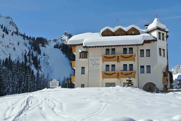 Alpine lodge exterior with direct access to groomed ski slopes