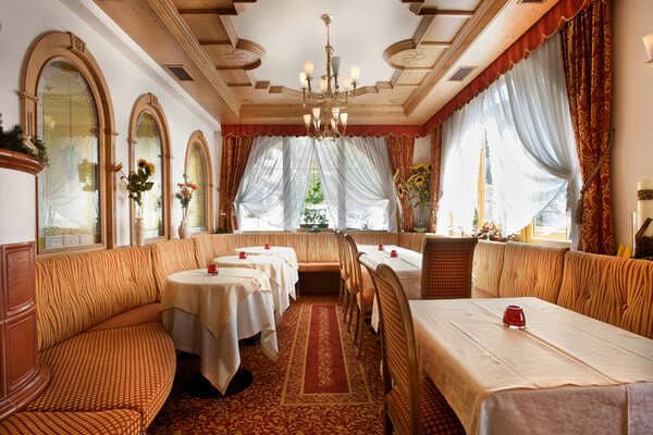 Dining area with wrap-around banquette seating and ornate chandelier