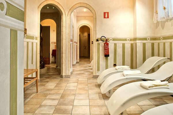 Spa relaxation room with three loungers and decorative arched hallways