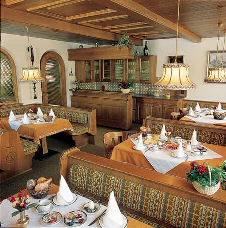 Dining area with booth seating and traditional wood-paneled breakfast bar