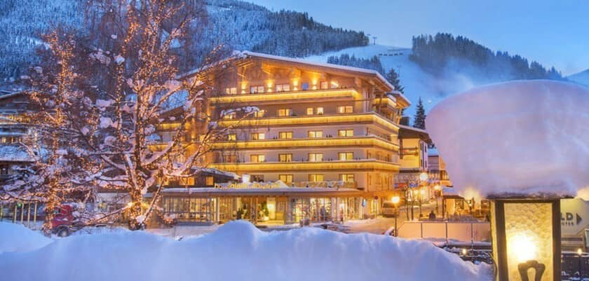 Ski-in lodge exterior with lighted balconies and mountain view