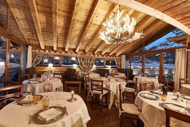 Dining room with antler chandelier and snowy mountain views