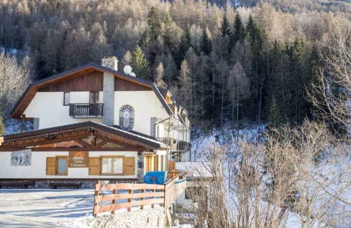 Chalet exterior with mountain forest backdrop and private balcony