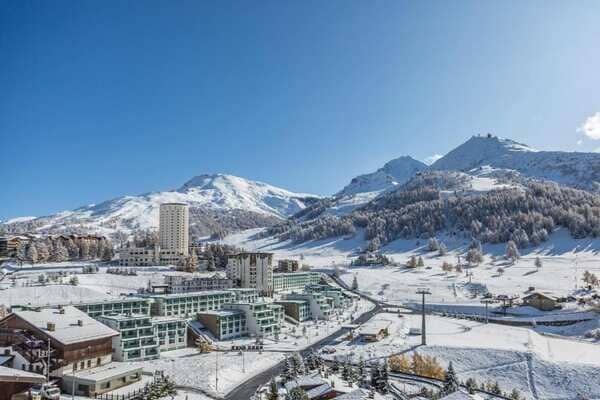 Ski resort view with mountain peaks and visible gondola lift access