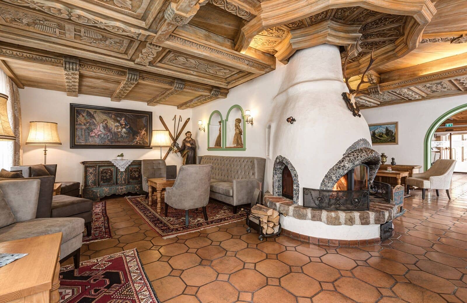 Lounge with wood-burning masonry fireplace and hand-carved timber ceiling