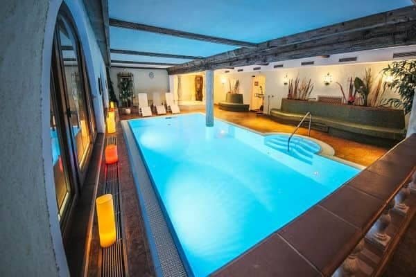 Indoor heated pool with timber beams and integrated bench seating