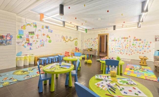 Kids' playroom with art stations, low seating, and dedicated activity tables