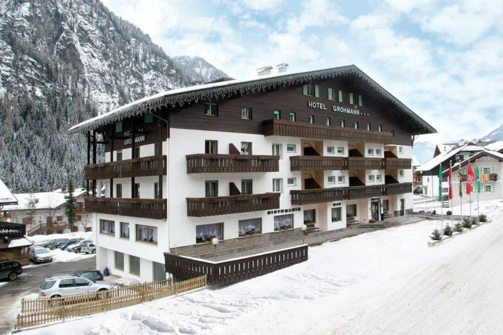 Alpine hotel exterior with private balconies and mountain backdrop