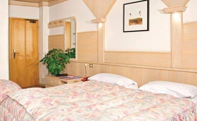 Bedroom with king bed and light wood paneled walls