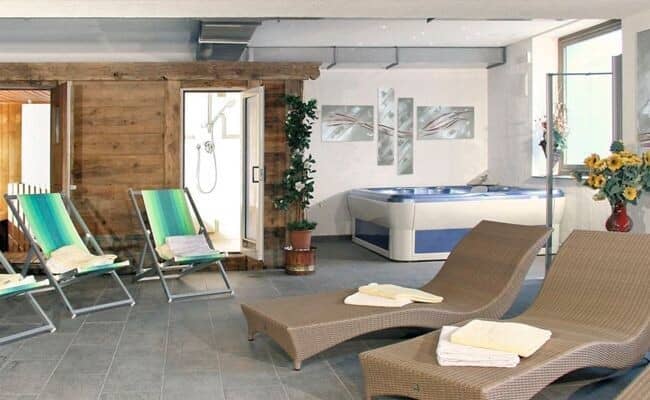 Indoor wellness area with hot tub, sauna access, and walk-in shower
