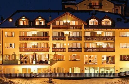 Chalet exterior at night with private balconies and snow-covered grounds