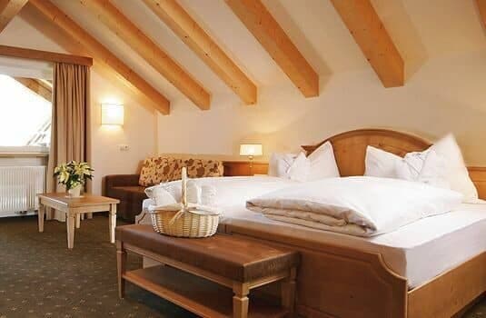 Guest bedroom with king bed, vaulted beamed ceilings, and seating area