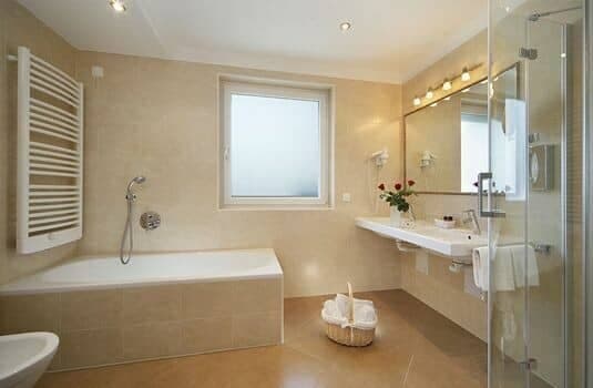 Bathroom with soaking tub, walk-in shower, and heated towel rack