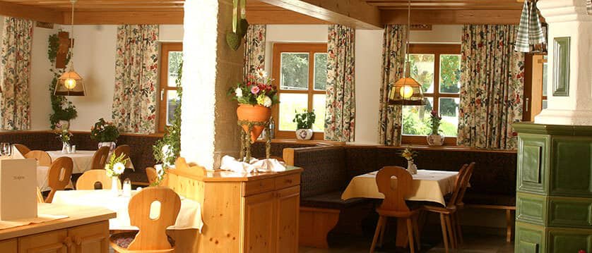 Dining area with booth seating and traditional kachelofen tile stove