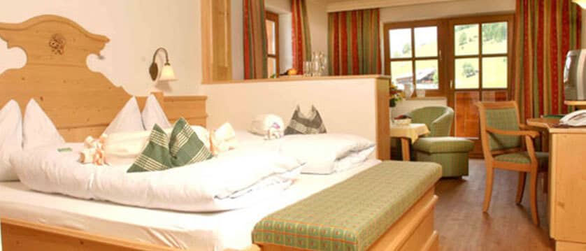 Guest suite with king bed and separate sitting area near balcony