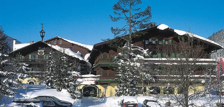 Chalet exterior with timber balconies and on-site parking area