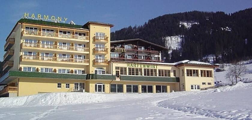 Ski-in/ski-out hotel exterior with private balconies and mountain backdrop